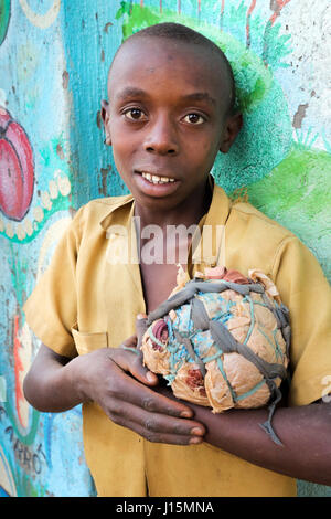 Young boy (12 years) with his self-made football made of fabric scraps and plastic bags in a village near Ruhengeri, Rwanda, Africa Stock Photo