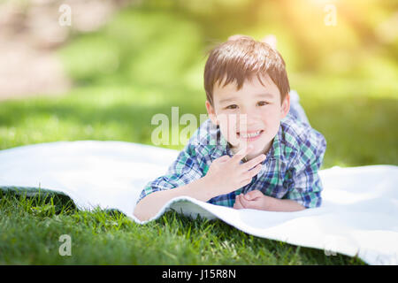 Mixed Race Chinese and Caucasian Young Boy Relaxing Outside On The Grass Stock Photo