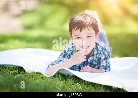 Mixed Race Chinese and Caucasian Young Boy Relaxing Outside On The Grass Stock Photo