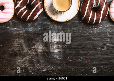 Donuts and coffee on black background. Top view with copy space Stock Photo