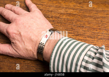 A medical alert wristband on a man's wrist Stock Photo