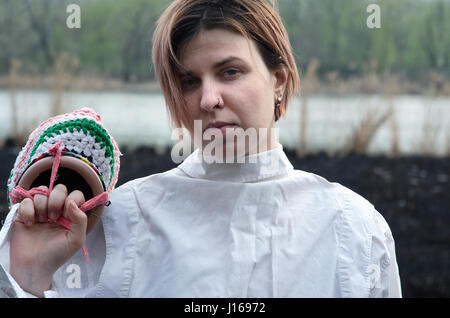 Burned land, girl, white shirt and colorful knitted head Stock Photo