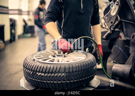 Mechanic man working on tire Stock Photo