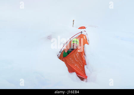 A Smiling Mountaineer Looking outside His Snow Buried Tent On Denali In Alaska Stock Photo