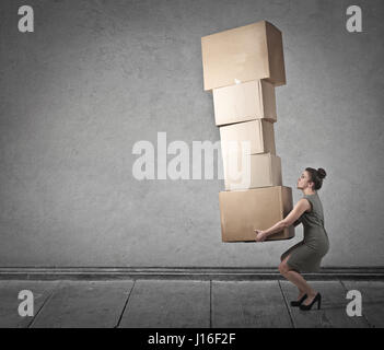 Woman carrying heavy boxes in empty room Stock Photo