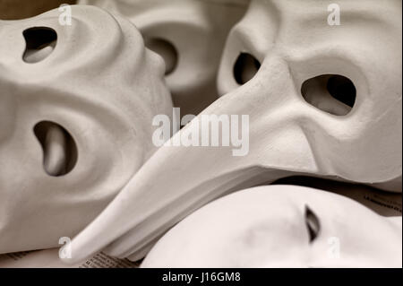 Backgrounds and textures: big group of unfinished traditional Venice masks, plain white paper Stock Photo