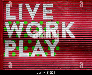 Live Work Play sign painted on roller shutter door, Hull Fruit Market area, UK. Stock Photo