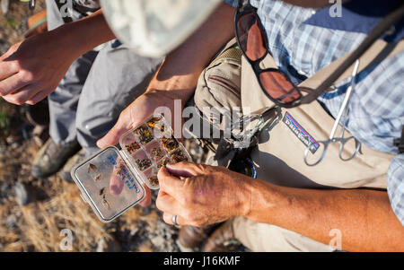 A Man Choosing A Fly From Fly Box While Fishing On Big Wood River In Ketchum, Idaho Stock Photo
