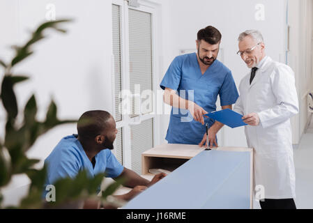 Happy medical coworkers sharing opinions in the clinic Stock Photo