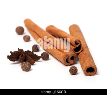Black peppercorns, anise stars and cinnamon sticks on white background. Selective focus Stock Photo