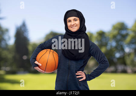 happy muslim woman in hijab with basketball Stock Photo