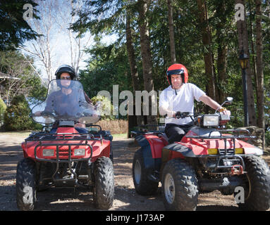 young couple riding a quad vehicle Stock Photo