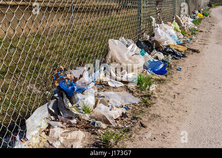 Ronneby, Sweden - March 27, 2017: Documentary of public waste station. Litter stuck in the fence beside a road. Stock Photo