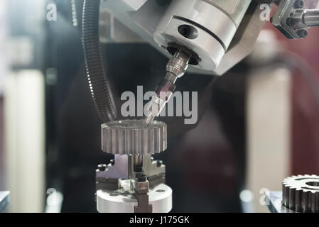 The five-axis Computer Numerical Control (CNC) machine while cutting sample gear part. Indutrial machine. Stock Photo
