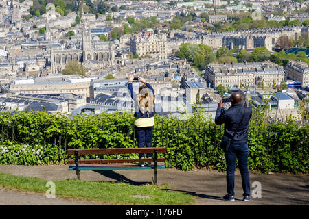 Bath, UK. 18th Apr, 2017. A man and a woman taking advantage of the warm spring sunshine and a high vantage point are pictured in Alexandra Park as they take photographs of the city of Bath. Credit: lynchpics/Alamy Live News Stock Photo