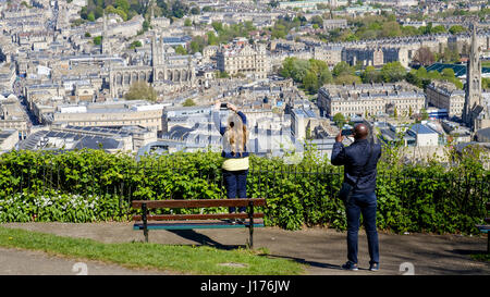 Bath, UK. 18th Apr, 2017. A man and a woman taking advantage of the warm spring sunshine and a high vantage point are pictured in Alexandra Park as they take a photograph of the city of Bath. Credit: lynchpics/Alamy Live News Stock Photo