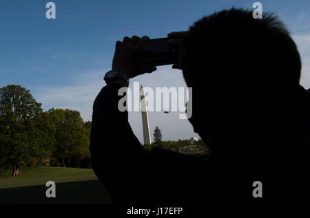 Washington, USA. 18th Apr, 2017. A visitor takes a photo as Marine One, carrying United States President Donald Trump returns to the White House in Washington, DC on April 18, 2017. President Trump is returning form a day trip to Kenosha, Wisconsin where he visited Snap-on tools. Credit: MediaPunch Inc/Alamy Live News Stock Photo