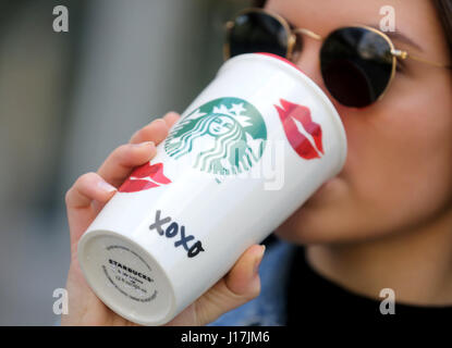 Hanna drinks coffee out of a reusable cardboard cup in Duisburg, Germany, 19 April 2017. Customers can save 30 cents on their hot beverages if they bring their own cups. Photo: Roland Weihrauch/dpa Stock Photo