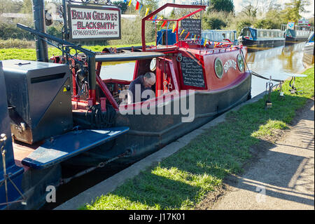 Brian Greaves, blacksmith at work on his boat Bronte moored at Nantwich Stock Photo