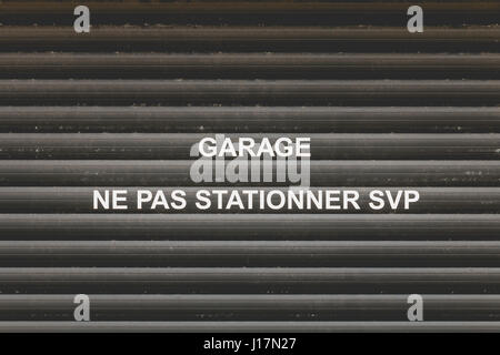 black garage door with the mention in French "Garage Do not Parking" Stock Photo