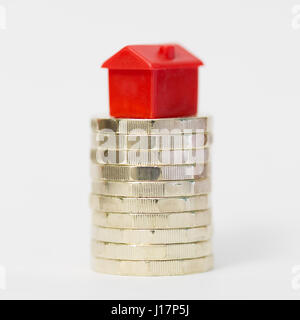 Concept image depicting housing/property markets on stack of new British pound (£) coins. Stock Photo