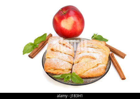 Buns with apple, cinnamon and mint sprinkled with powdered sugar on a plate, and red apple with heart.  Isolated on white background. Stock Photo