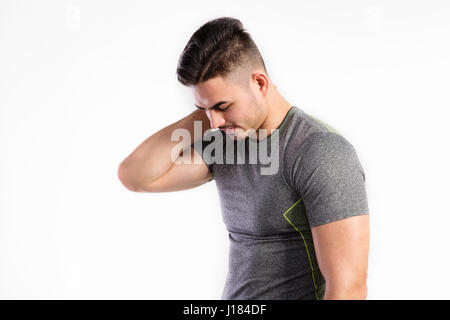 Young handsome fitness man in gray t-shirt, studio shot. Stock Photo