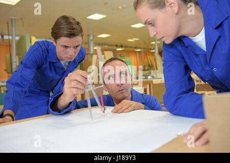 Trainees watching tutor using compass Stock Photo
