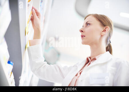 Professional removing medicine box from shelf Stock Photo