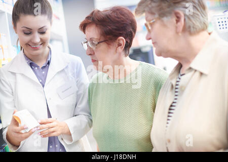 Pharmacists with mature clients in drug store Stock Photo
