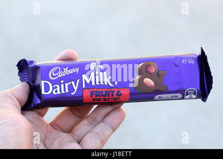 Hand holding Australia Cadbury Fruit and Nut chocolate bar isolated Stock Photo