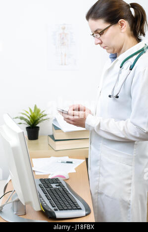 Portrait of a female doctor using smartphone in her office Stock Photo
