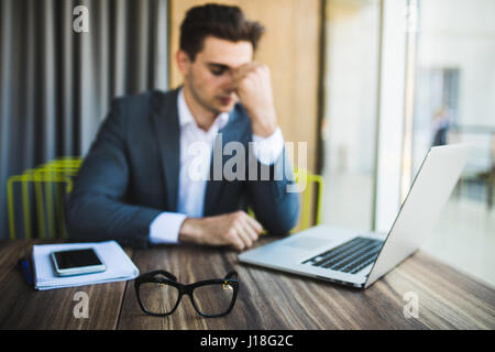 Young businessman stressed jobs headaches about the job on table. Stock Photo