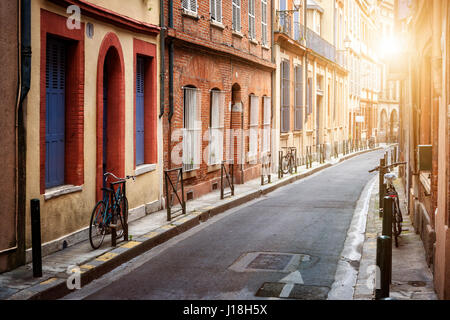 Warm sunlight on narrow street  in old center of Toulouse, France. Stock Photo