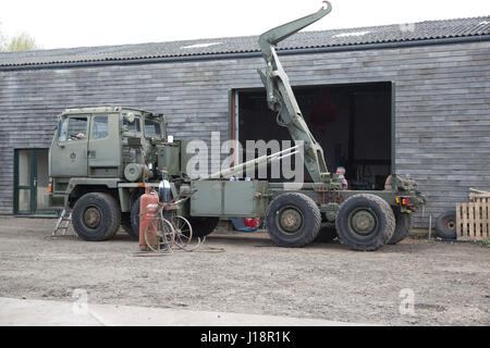 Ex army military 8WD all wheel drive khaki green truck with rear mounted crane lift being restored Cheltenham UK Stock Photo