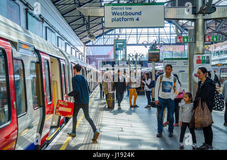 A man boards a District Line train at Earl's Court London Underground Station. Stock Photo