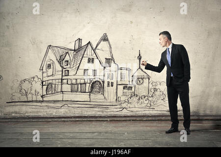 Businessman in front of drawn house Stock Photo