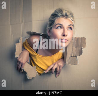 Woman breaking through paper box Stock Photo