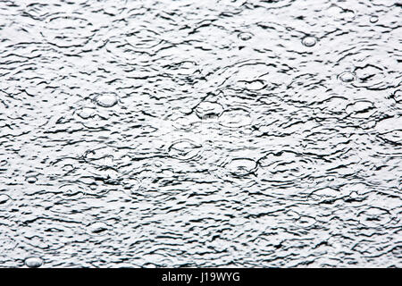 Abstract photo of water falling on glass creating patterns. Stock Photo