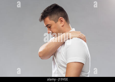 unhappy man suffering from pain in shoulder Stock Photo