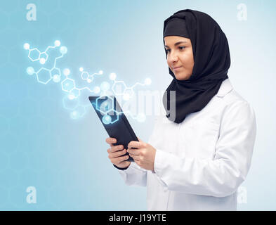 muslim female with tablet pc and chemical formula Stock Photo