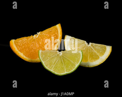 Orange Lime and Lemon Segments Against a Black Background Stock Photo