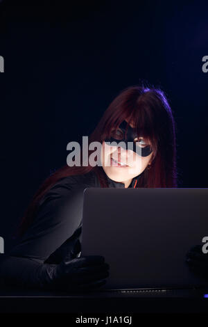 Woman in mask with laptop Stock Photo