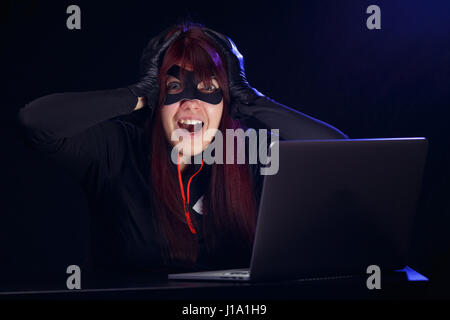 Brunette steals information from computer Stock Photo