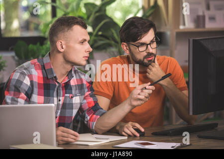 Young men programmers working together in the office  Stock Photo
