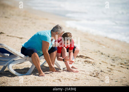 people on beach looking for sea shells Stock Photo