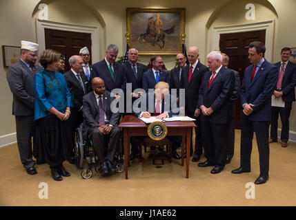 Washington DC, USA. 19th April, 2017. United States President Donald Trump signs S. 544 the Veterans Choice Program Extension and Improvement Act in the Roosevelt Room at the White House in Washington, DC on April 19, 2017. Credit: Molly Riley/Pool via CNP /MediaPunch/Alamy Live News Stock Photo