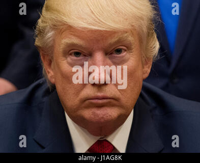 Washington, USA. 19th Apr, 2017. United States President Donald Trump listens after signing the S. 544 the Veterans Choice Program Extension and Improvement Act in the Roosevelt Room at the White House in Washington, DC on April 19, 2017. Credit: MediaPunch Inc/Alamy Live News Stock Photo