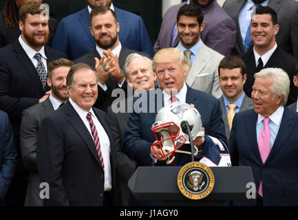 Washinton D.C., USA. 19th Apr, 2017. U.S. President Donald Trump (C) receives a helmet of New England Patriots at a ceremony welcoming the visit of the Super Bowl Champion New England Patriots on the South Lawn of the White House in Washington, DC, the United States, April 19, 2017. Credit: Yin Bogu/Xinhua/Alamy Live News Stock Photo