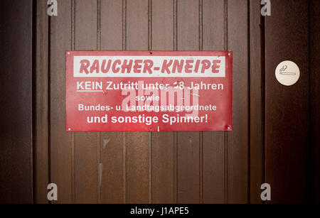 A sign reading 'Raucher-Kneipfe' (lit. 'Smokers' Pub' can be seen at a bar in Hanover, Germany, 20 April 2017. The sign forbids the entrance of people under the age of 18 as well as 'Members of the federal or state parliaments and other weirdos!'. Photo: Julian Stratenschulte/dpa Stock Photo